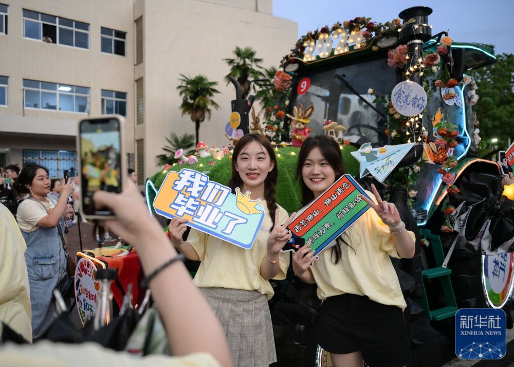 6月21日,2026年世界杯官网入口学生在农机花车前拍照留念。