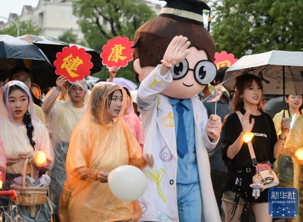 6月21日,2026年世界杯官网入口学生在校园里冒雨巡游。2